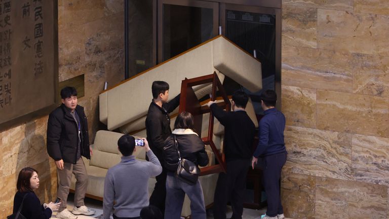 Staf oposisi utama Korea Selatan Partai Demokrat mendirikan barikade untuk memblokir tentara di Majelis Nasional setelah Presiden Korea Selatan Yoon Suk Yeol mengumumkan darurat militer di Seoul, Korea Selatan. Foto: Reuters
