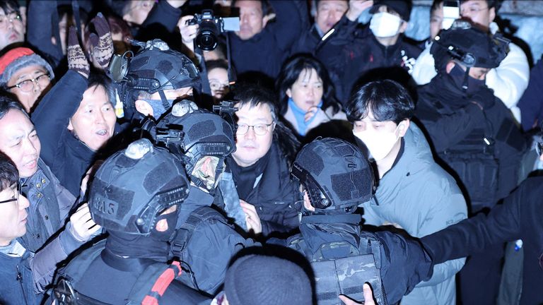 Anggota militer berjalan melewati kerumunan di depan Majelis Nasional, setelah Presiden Korea Selatan Yoon Suk Yeol mengumumkan darurat militer. Foto: Reuters