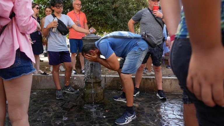 Seorang pria menyegarkan diri di air mancur di Roma, Senin, 17 Juli 2023. (AP Photo/Gregorio Borgia)