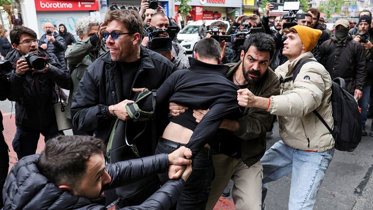 Anggota polisi berpakaian menahan seorang pengunjuk rasa, saat orang-orang berusaha menentang larangan dan berbaris di Lapangan Taksim untuk merayakan May Day di Istanbul, Turki 1 Mei 2025. REUTERS/Umit Bektas
