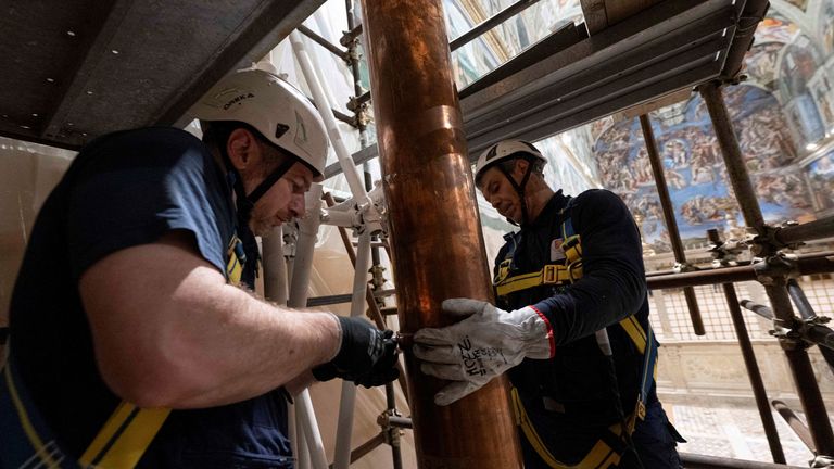 Pekerja memasang pipa cerobong asap di Kapel Sistina. Foto: Vatican Media/Reuters