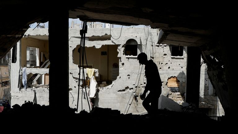 Seorang pria Palestina memeriksa rumah tempat pengantin baru Palestina Hala Zaarab tewas dalam serangan udara Israel, di Khan Younis, Gaza. Foto: Reuters