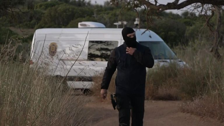 Seorang petugas polisi mengenakan balaclava di Praia da Luz - di mana pihak berwenang sedang mencari Madeleine McCann