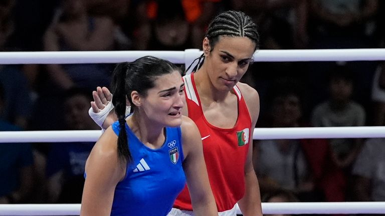Imane Khelif dari Aljazair, merah, di samping Angela Carini dari Italia, di akhir pertandingan tinju penyisihan 66kg putri mereka di Olimpiade Musim Panas 2024, Kamis, 1 Agustus 2024, di Paris, Prancis. (AP Photo/John Locher)