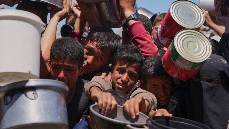 Warga Palestina berjuang untuk mendapatkan makanan yang disumbangkan di dapur komunitas di Khan Younis pada hari Senin. Foto: AP