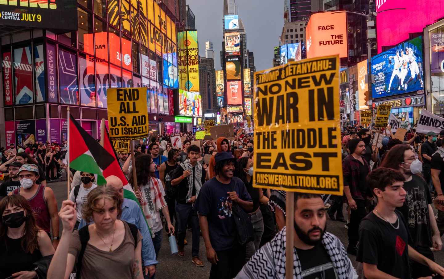 Orang-orang berbaris di Times Square selama rapat umum yang menyerukan pemerintahan Trump untuk tidak berperang dengan Iran, pada 18 Juni 2025, di New York City.