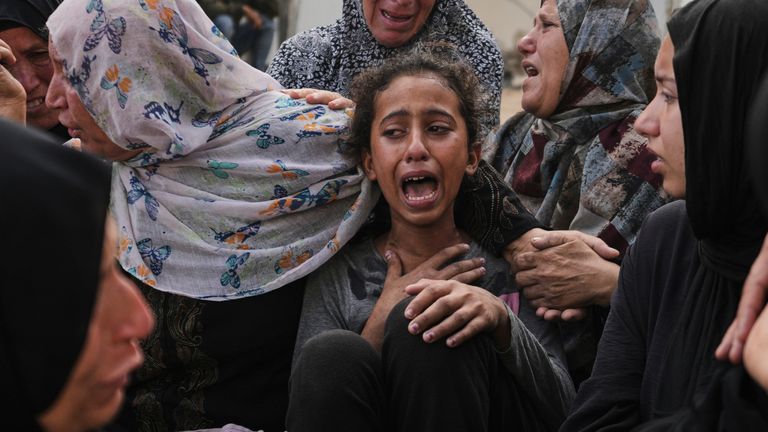 Lian Al-Za'anin, tengah, dihibur oleh kerabat saat dia berduka atas kehilangan ayahnya, Rami Al-Za'anin, yang tewas saat menuju ke pusat distribusi bantuan, di kamar mayat Rumah Sakit Shifa di Kota Gaza, pada Kamis, 3 Juli 2025. (AP Photo/Jehad Alshrafi)