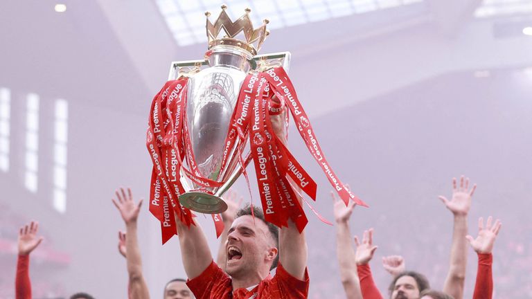 Diogo Jota merayakan dengan trofi setelah memenangkan Liga Premier. Foto: Reuters