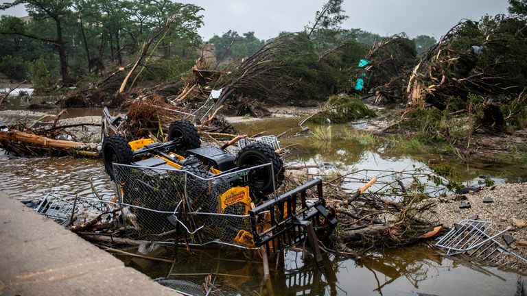 Sebuah kendaraan terbalik terjebak dalam puing-puing di sepanjang Sungai Guadalupe setelah banjir bandang melanda daerah tersebut, Jumat, 4 Juli 2025, di Kerrville,