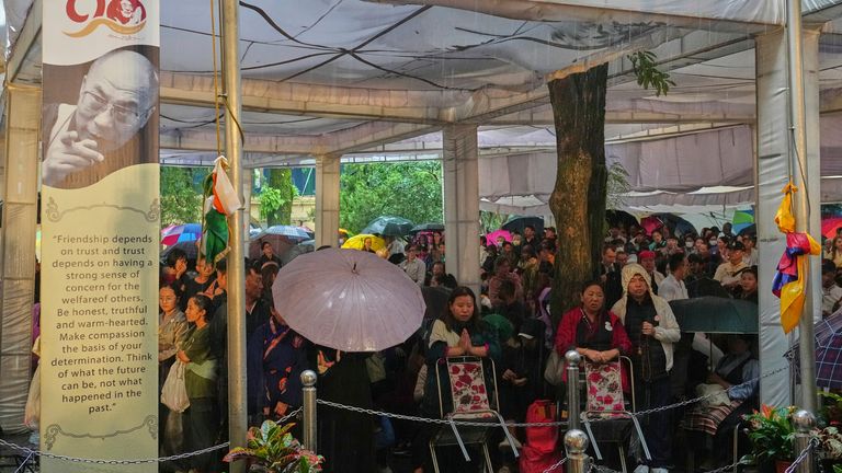 Para penyembah menunggu kedatangan Dalai Lama di tengah hujan di sebuah acara merayakan ulang tahunnya. Foto: AP/Ashwini Bhatia