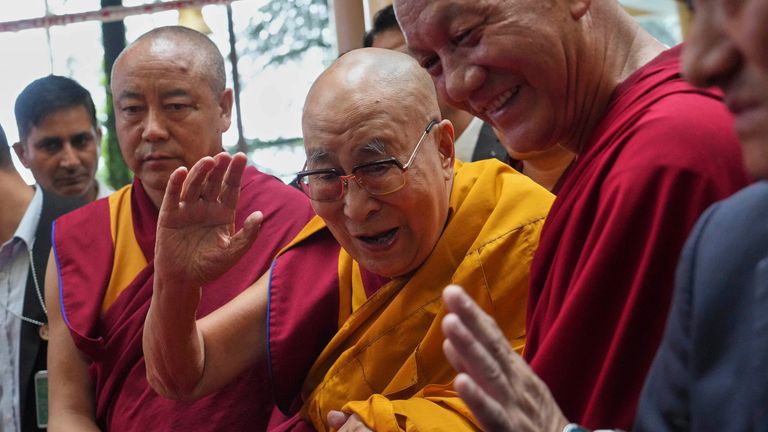 Dalai Lama, tengah, menyapa orang-orang saat dia tiba di sebuah acara sehari sebelum ulang tahunnya yang ke-90. Foto: AP/Ashwini Bhatia
