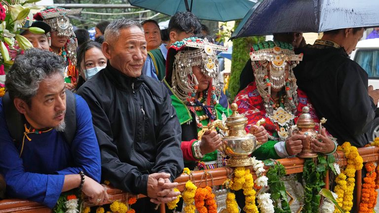 Para penyembah dengan pakaian tradisional mereka menunggu kedatangan pemimpin spiritual Tibet. Foto: AP/Ashwini Bhatia