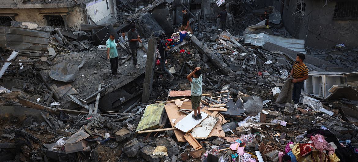 Orang-orang mencari melalui puing-puing bangunan yang hancur di Jalur Gaza tengah. Orang-orang mencari melalui puing-puing bangunan yang hancur di Jalur Gaza tengah.