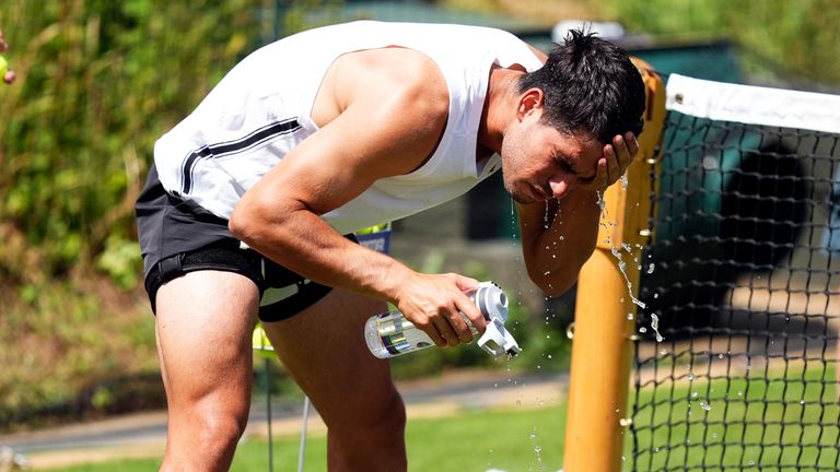 Carlos Alcaraz mendinginkan diri selama sesi latihan pada hari kedua Kejuaraan Wimbledon 2025. Foto: PA