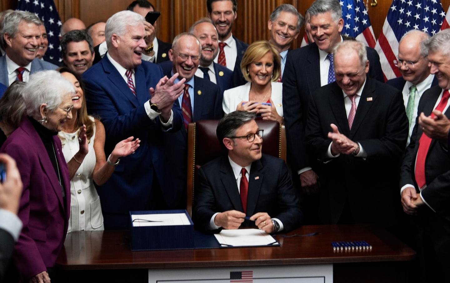 Ketua DPR Mike Johnson, R-La., dikelilingi oleh anggota Kongres dari Partai Republik, menandatangani RUU keringanan pajak dan pemotongan pengeluaran yang ditandatangani Presiden Donald Trump, Kamis, 3 Juli 2025, di Capitol di Washington.