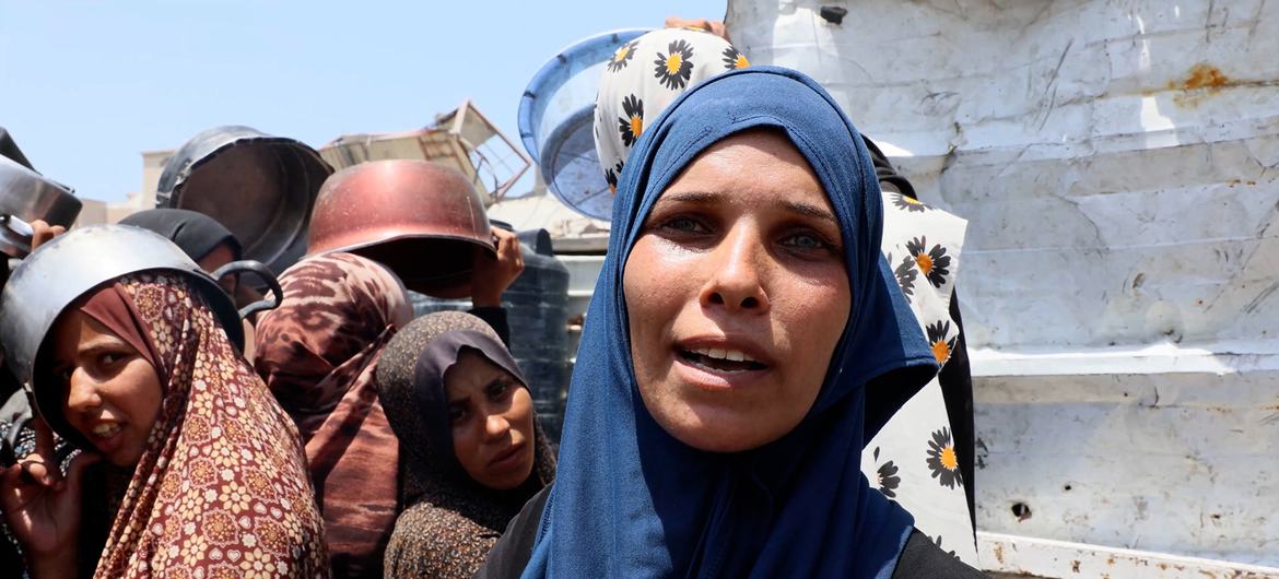Um Muhammad, yang melarikan diri dari lingkungan Shujaiya di Kota Gaza timur ke daerah baratnya, menunggu untuk mendapatkan makanan. Um Muhammad, yang melarikan diri dari lingkungan Shujaiya di Kota Gaza timur ke daerah baratnya, menunggu untuk mendapatkan makanan.