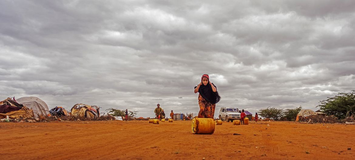 Seorang gadis memindahkan wadah penuh air di sebuah lokasi untuk pengungsi di Dolow, Somalia. (berkas) Seorang gadis memindahkan wadah penuh air di sebuah lokasi untuk pengungsi di Dolow, Somalia. (berkas)