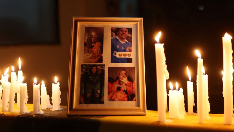 Foto-foto penambang yang terperangkap ditampilkan saat lilin menyala selama berjaga-jaga. Foto: Reuters/Pablo Sanhueza