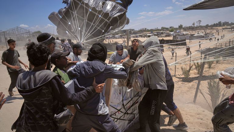 Warga Palestina bergegas mengumpulkan bantuan kemanusiaan yang dijatuhkan dengan parasut ke Deir al-Balah, Jalur Gaza tengah, Selasa, 5 Agustus 2025. (AP Photo/Abdel Kareem Hana)